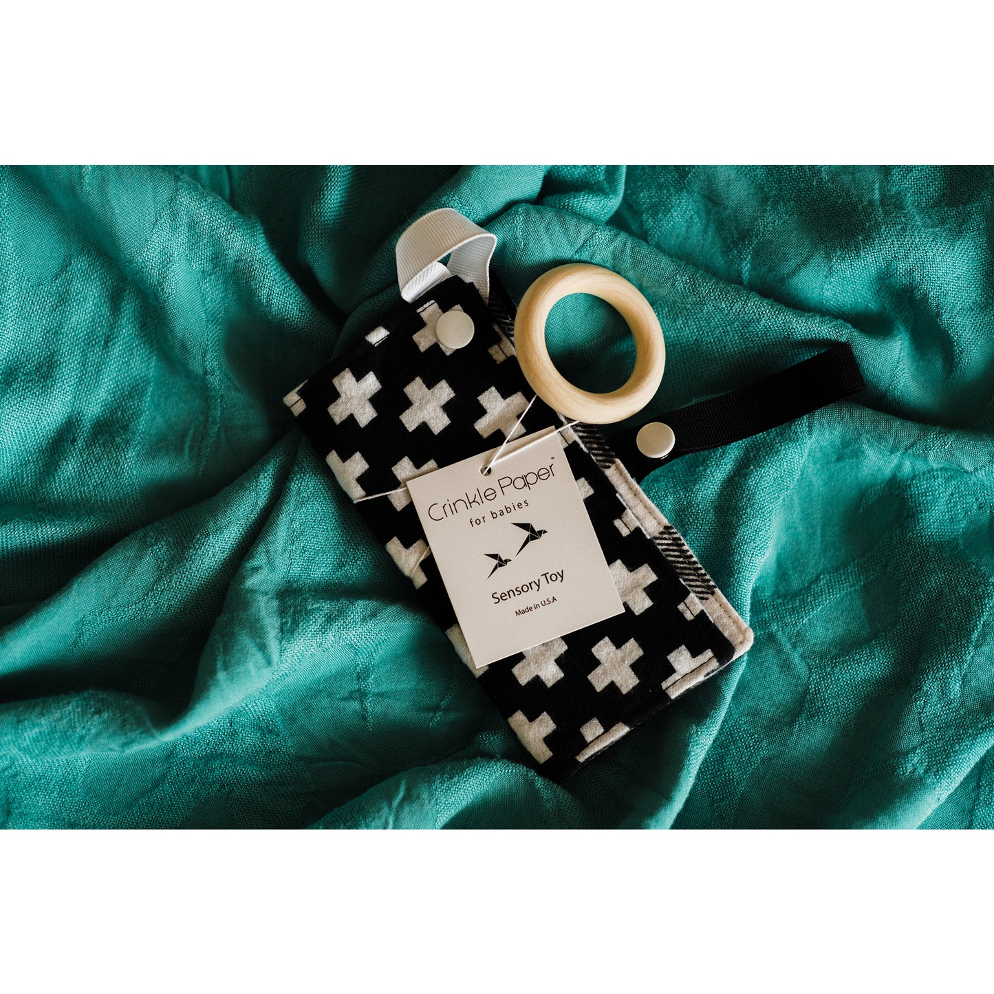 black and white, Swiss cross print fabric crinkle paper for babies by Hyak Designs. Infant sensory and auditory toy makes 'crinkle' sound and beech wood ring.
